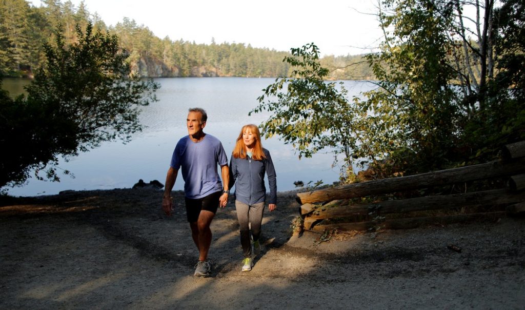Robyn Meagher and Jason Dorland walking together beside a lake