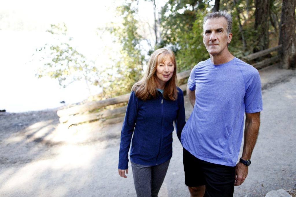 Robyn Meagher and Jason Dorland standing together on a wooded path