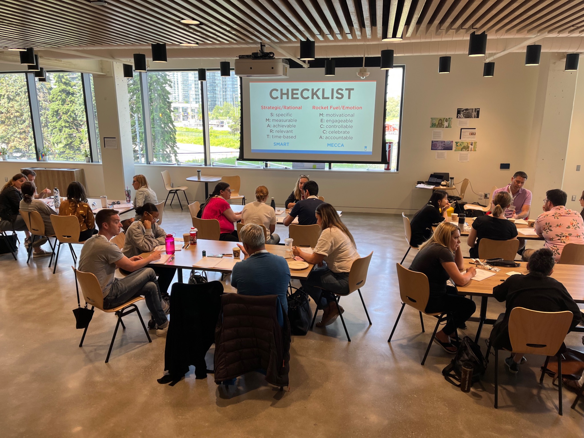 Workshop participants engaged in small-group conversations around tables
